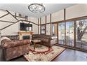 Comfortable living room with dark wood floors, traditional fireplace, and leather furniture at 3653 Calabria Ave, Davenport, FL 33897