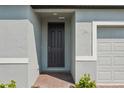 Elegant front door with brick entryway, modern gray siding, and well-maintained landscaping at 3809 Giorgio Dr, Winter Haven, FL 33884