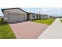 Charming home featuring a paved driveway, well-kept lawn, and inviting facade with a modern garage door at 3860 Giorgio Dr, Winter Haven, FL 33884