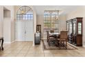 Dining room with tiled floors, large windows, a dining table set and a decorative cabinet at 736 W Pinewood Ct, Lake Mary, FL 32746