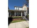 Charming two-story home with inviting front porch and manicured landscaping at 7873 Dausset St, Orlando, FL 32827