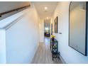 Bright foyer and hallway with light-wood tile, white walls, and stairwell at 929 Conch Rd, Davenport, FL 33896