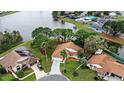 Beautiful aerial shot of a home with a well-manicured yard, driveway, and access to a serene lake at 100 Honeywood Ct, Kissimmee, FL 34743