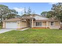 Inviting single-story home with manicured lawn, neutral paint, white trim, and an attached two-car garage at 100 Honeywood Ct, Kissimmee, FL 34743