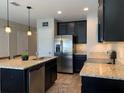 Well-lit kitchen featuring an island with sink, modern appliances and granite countertops at 1013 Flowing Tide Dr, Orlando, FL 32828