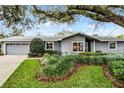 Lovely home features manicured landscaping around a gray exterior and a well-kept lawn at 112 E Cumberland Cir, Longwood, FL 32779