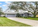 Well-maintained single-story home with gray exterior and a long driveway, complemented by a healthy green lawn at 112 E Cumberland Cir, Longwood, FL 32779