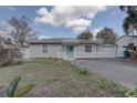 Charming single-story home featuring a bright blue door, a white picket fence, and a detached garage at 1129 Ne 12Th St, Ocala, FL 34470