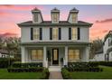 Charming two-story home with a welcoming front porch and meticulously landscaped yard at dusk at 11402 Camden Loop Way, Windermere, FL 34786