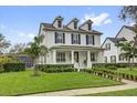 Beautiful two-story home featuring a manicured lawn, a white picket fence, and mature landscaping at 11402 Camden Loop Way, Windermere, FL 34786