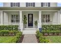 Inviting front porch with decorative plants, a brick walkway, and a stylish glass-paneled front door at 11402 Camden Loop Way, Windermere, FL 34786