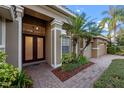 Inviting front entrance with a brick paved walkway, well manicured landscaping, and a double door entry into the home at 11733 Delwick Dr, Windermere, FL 34786