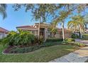 Gorgeous one-story home boasting lush landscaping, a terracotta roof, a two car garage, and a charming brick paved driveway at 11733 Delwick Dr, Windermere, FL 34786