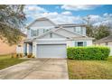 Charming two-story home featuring a gray exterior, two-car garage, and manicured lawn at 1317 Independence Ln, Mount Dora, FL 32757