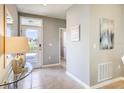 Welcoming entryway featuring neutral walls, tile flooring, and a glass table with decorative lamps at 1807 Waggoner St, Kissimmee, FL 34744