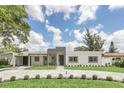 Landscaped modern home with a stone driveway and striking architectural details at 2015 Summerfield Rd, Winter Park, FL 32792