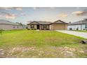 Inviting single-story home features a manicured lawn enhancing its curb appeal with neutral tones at 212 Fig Ct, Poinciana, FL 34759