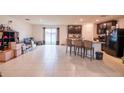 Spacious living room featuring tile floors, sliding glass doors, and an open layout with a kitchen island at 212 Fig Ct, Poinciana, FL 34759