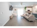 Open-concept living room with tile flooring and a view into the modern kitchen at 2715 Rowan St, Tavares, FL 32778