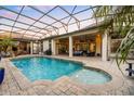 Inviting screened-in pool area with brick pavers, covered patio, outdoor kitchen, and lush landscaping offering a private backyard oasis at 3123 Bentonshire Pl, Longwood, FL 32779