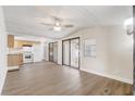 Open-concept living room with laminate floors, ceiling fan, and modern sliding glass doors at 34936 3Rd Ave, Leesburg, FL 34788