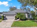 Charming single-story home with a well-maintained lawn, mature trees, and a two-car garage at 398 Lake Amberleigh Dr, Winter Garden, FL 34787