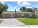 Brick home with a driveway and well maintained front yard and appealing landscaping at 420 Sylvan Dr, Winter Park, FL 32789