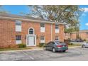 A brick two-story condo building with a reserved parking spot in front and mature landscaping at 4212 Lake Underhill Rd # 5, Orlando, FL 32803