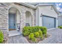 Inviting front entrance with stone accents, arched columns, and a cozy seating area at 4426 Davos Dr, Clermont, FL 34711