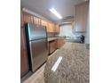 Updated kitchen with stainless steel appliances, granite countertops, and maple colored cabinets at 4822 Conway Rd # 125, Orlando, FL 32812