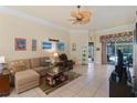 Bright living room featuring tile floors, ceiling fan, and access to the outdoor area at 501 Sotheby Way, Debary, FL 32713