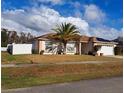 Charming single-story home with a well-maintained lawn, palm tree and white fence at 550 Oak Branch Cir, Kissimmee, FL 34758