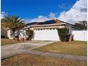 Charming single-story home with a well-maintained lawn, palm tree and two-car garage at 550 Oak Branch Cir, Kissimmee, FL 34758