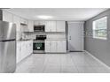 Bright kitchen featuring white cabinets, stainless steel appliances, and tile flooring at 630 N Nashua Ave, Fort Meade, FL 33841