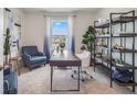 Well-lit home office featuring a large window, modern desk, comfortable seating, and ample shelving at 7071 Painted Bunting Way, St Cloud, FL 34773