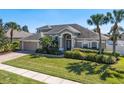 Charming two-story home featuring a well-manicured lawn, brick driveway, and mature landscaping at 713 Duff Dr, Winter Garden, FL 34787