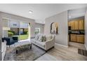 Open-concept living room with a large sliding glass door, neutral decor, and wood-look flooring at 723 Marotta Loop, Ocoee, FL 34761