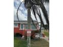 A red stucco home featuring decorative anchor detail, surrounded by green grass and a palm tree at 833 E 24Th Ave # 106, New Smyrna Beach, FL 32169