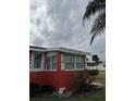 Red stucco home with white trim featuring a decorative anchor and a cloudy sky background at 833 E 24Th Ave # 106, New Smyrna Beach, FL 32169