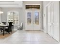 Elegant foyer featuring a white door with decorative glass panels and a neutral tiled floor leading to other rooms at 8718 Shimmering Pine Pl, Sanford, FL 32771