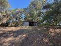 Old shed structure located on a lot surrounded by mature trees at 8801 Hackney Prairie Rd, Orlando, FL 32818