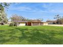 Picture of the rear exterior of the house with a large yard and screened in back porch at 926 Ensenada Dr, Orlando, FL 32825