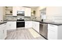 Bright kitchen featuring white cabinets, stainless steel appliances, and gray backsplash at 938 S Bumby Ave, Orlando, FL 32806