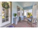 Inviting front porch with brick flooring, comfortable seating, plants and door with wreath at 13333 Beebe Aly, Orlando, FL 32827