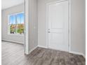 Bright entryway featuring wood-look floors, white door, and a view to the side yard at 13348 Panama Beach Ct, Orlando, FL 32827