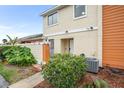 Charming two-story townhome with tidy front yard featuring mature shrubs and plants at 15 Silver Park Cir, Kissimmee, FL 34743