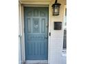 Charming blue front door with decorative details, mailbox, and lantern, creating a welcoming entrance at 161 Randia Dr, Orlando, FL 32807