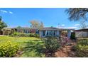 Single-story home with tidy landscaping, blue shutters, and an attached carport on a sunny day at 161 Randia Dr, Orlando, FL 32807