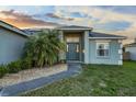 Front entrance adorned with a decorative palm tree and well-maintained landscaping at 1879 Grey Fox Dr, Lakeland, FL 33810