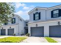Charming townhomes with two stories, gray paint, black shutters, and attached garages at 20648 Maxim Pkwy Pkwy, Orlando, FL 32833